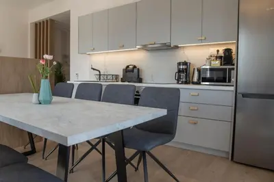 a kitchen with white cabinets and a table with chairs at Athens Life in Athens