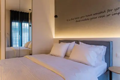 a bed with white pillows and a sign on the wall at Athens Life in Athens