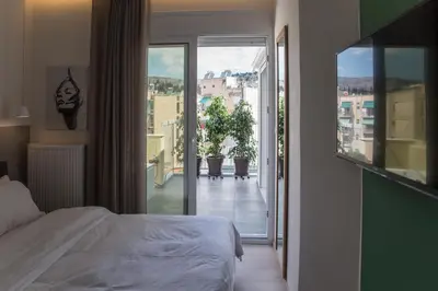 a bedroom with a bed and a view of a balcony at Athens Luxury in Athens