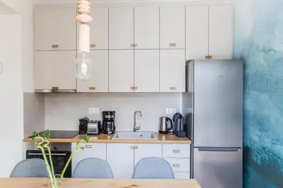 a kitchen with white cabinets and a stainless steel refrigerator at Athens Luxury in Athens