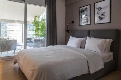 a bedroom with a large white bed with a balcony at Athens Luxury in Athens