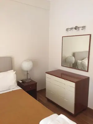 a bedroom with a dresser and a mirror on the wall at Athens beautiful SUITE by Gela in Athens