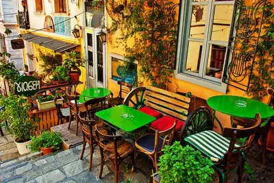 an outdoor patio with tables and chairs and a bench at Athens beautiful SUITE by Gela in Athens
