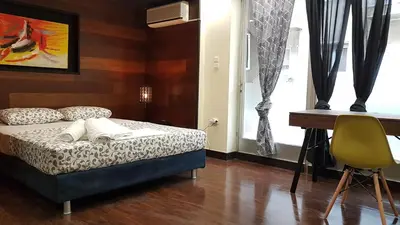 a bedroom with a bed and a desk and a chair at Errathens Cherry and Berry Apartments - Athens Center in Athens