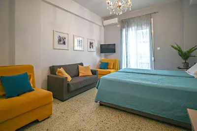 a bedroom with a bed and a couch and a chair at Urban Art Experience with Acropolis View in Athens