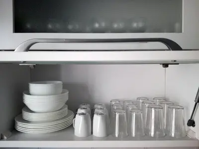 a shelf in a kitchen with plates and utensils at Urban Art Experience with Acropolis View in Athens
