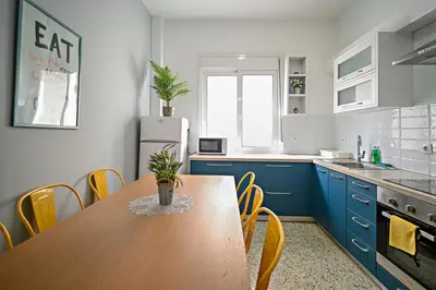 a kitchen with a wooden table and blue cabinets at Urban Art Experience with Acropolis View in Athens
