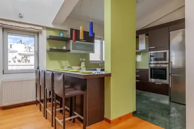 a kitchen with a bar with stools at Elvita Athens Sea View Maisonette in Athens
