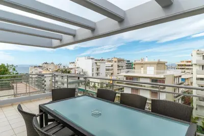 a balcony with a table and chairs and a view at Elvita Athens Sea View Maisonette in Athens