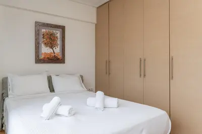 a bedroom with a white bed with towels on it at Elvita Athens Sea View Maisonette in Athens