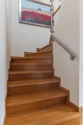 a stairwell with wooden stairs with a painting on the wall at Elvita Athens Sea View Maisonette in Athens