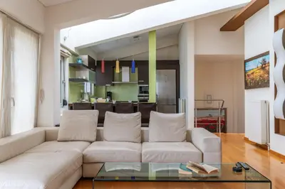 a living room with a white couch and a glass table at Elvita Athens Sea View Maisonette in Athens