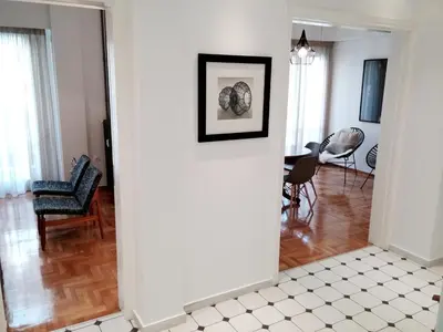 a living room with a white wall with a picture at New stylish Kolonaki flat in Athens