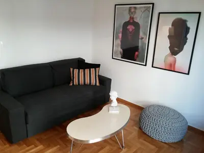 a living room with a black couch and a white table at New stylish Kolonaki flat in Athens
