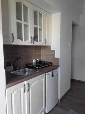 a kitchen with white cabinets and a sink at Apartment 