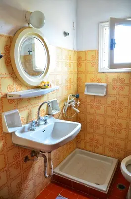 a bathroom with a sink and a mirror and a toilet at Vagia Beach Apartments, Aegina Island in Vaia