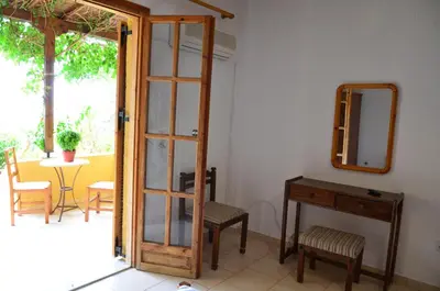 a room with a mirror and a table and chairs at Vagia Beach Apartments, Aegina Island in Vaia