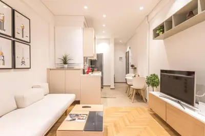a living room with a white couch and a kitchen at HiEnd 4th floor 1bdr in Athens