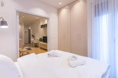 a bedroom with a white bed and a mirror at HiEnd 4th floor 1bdr in Athens