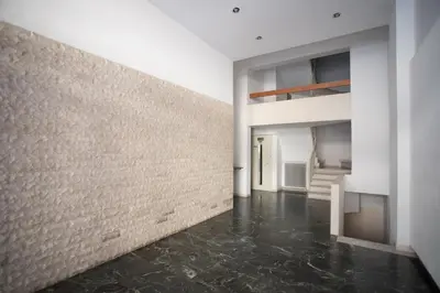 an empty room with a brick wall and a hallway at HiEnd 4th floor 1bdr in Athens