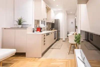 a kitchen with white cabinets and a dining room at HiEnd 4th floor 1bdr in Athens