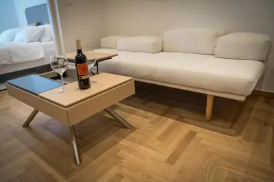 a living room with a couch and a table with a bottle of wine at HiEnd 4th floor 1bdr in Athens