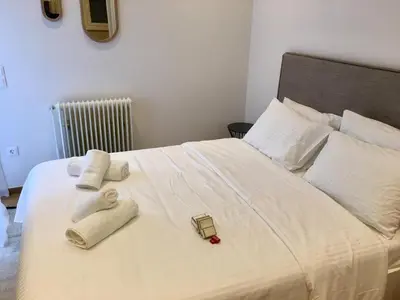 a white bed with towels and a cell phone on it at HiEnd 4th floor 1bdr in Athens
