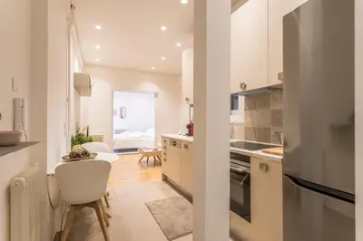 a kitchen with white cabinets and a table and chairs at HiEnd 4th floor 1bdr in Athens