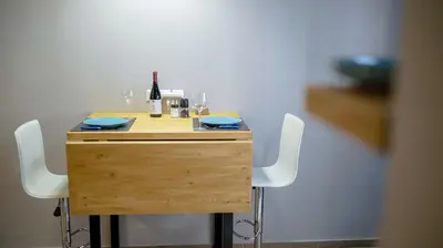 a wooden table with four chairs and a bottle of wine at D16 Athens Apartment - 5' mins to Petralona Metro in Athens