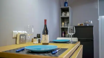 a bottle of wine and two glasses on a table at D16 Athens Apartment - 5' mins to Petralona Metro in Athens