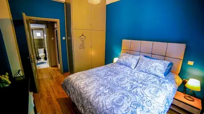 a bedroom with a bed with a blue wall at D16 Athens Apartment - 5' mins to Petralona Metro in Athens