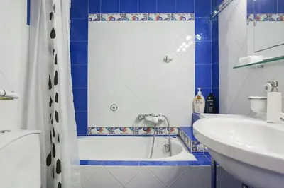 a blue and white bathroom with a tub and a sink at Cozy Flat in Heart of Acropolis in Athens