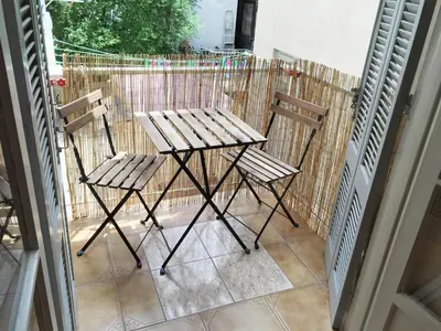 two wooden chairs and a table on a balcony at Cozy Flat in Heart of Acropolis in Athens