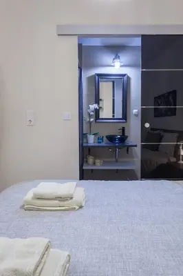 a bathroom with a bed and a sink and a mirror at A Gift in the Heart of Monastiraki A in Athens