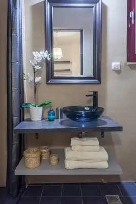 a bathroom with a sink and a mirror and towels at A Gift in the Heart of Monastiraki A in Athens