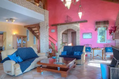 a living room with two couches and a table at Villa Sunrise Lagonisi in Lagonissi