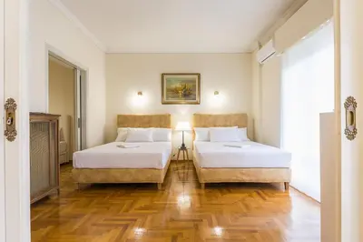 a hotel room with two beds and a couch at Victoria Queens Paradise Apartments in Athens
