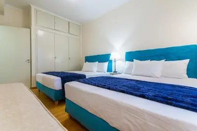 two beds in a room with blue and white at Victoria Queens Paradise Apartments in Athens