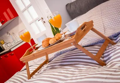 a tray of bread and two glasses of orange juice on a bed at Martin’s Akropolis loft in Athens