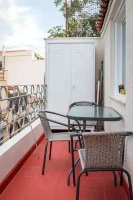a patio with a table and chairs on a balcony at Martin’s Akropolis loft in Athens