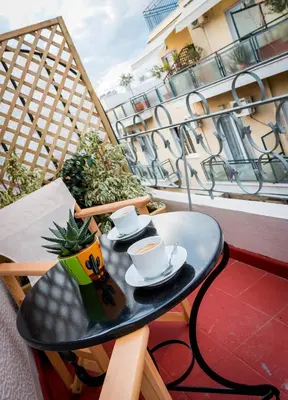 a table with two cups and saucers on a balcony at Martin’s Akropolis loft in Athens