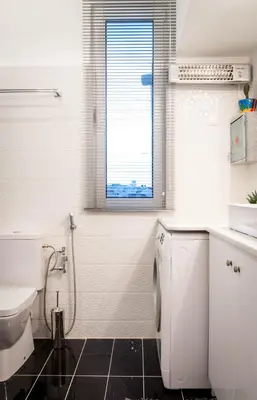 a white bathroom with a toilet and a window at Martin’s Akropolis loft in Athens