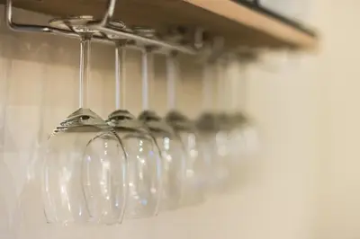 a row of wine glasses hanging from a rack at Family House next to Acropolis in Athens