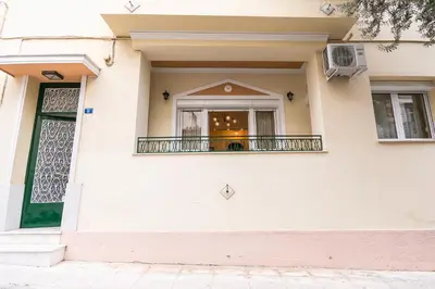 a white house with a balcony and a window at Family House next to Acropolis in Athens