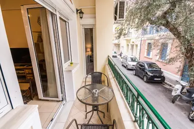a table on a balcony with a view of a street at Family House next to Acropolis in Athens