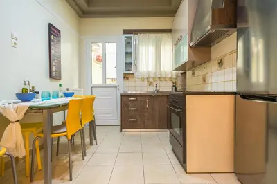 a kitchen with a table and yellow chairs at Family House next to Acropolis in Athens