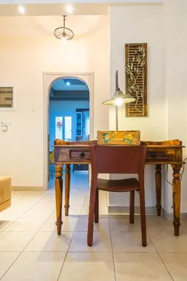 a dining room with a wooden table and a chair at Family House next to Acropolis in Athens