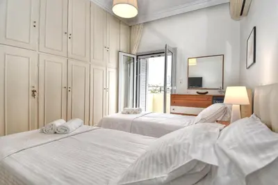 a bedroom with two beds and a mirror at Athens Authentic Elegance at Acropolis in Athens
