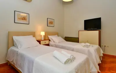 two beds in a room with a tv on the wall at Athens Authentic Elegance at Acropolis in Athens