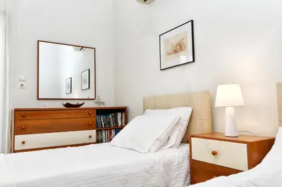 two beds in a bedroom with a dresser and a mirror at Athens Authentic Elegance at Acropolis in Athens